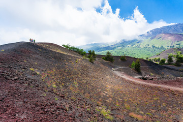 tourists walk on ridge between old crater
