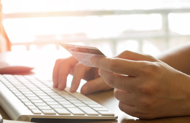 Hands holding credit card and using laptop. Online shopping