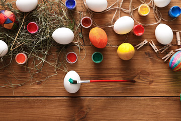 Painting colorful easter eggs background, top view on wood