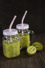 Fresh and healthy green Juice smoothie with kiwi and banana in glass jar. on dark background