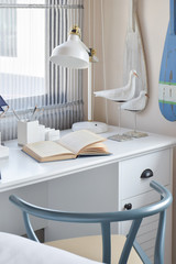 white table with wooden chair books and lamp in modern working area at home