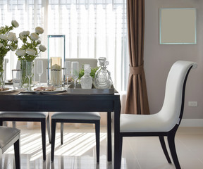 dining wooden table and comfortable chairs in modern home with elegant table setting