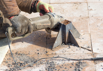 Worker cuts metal in the park
