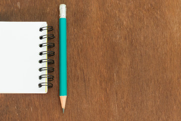 white note book with pencil