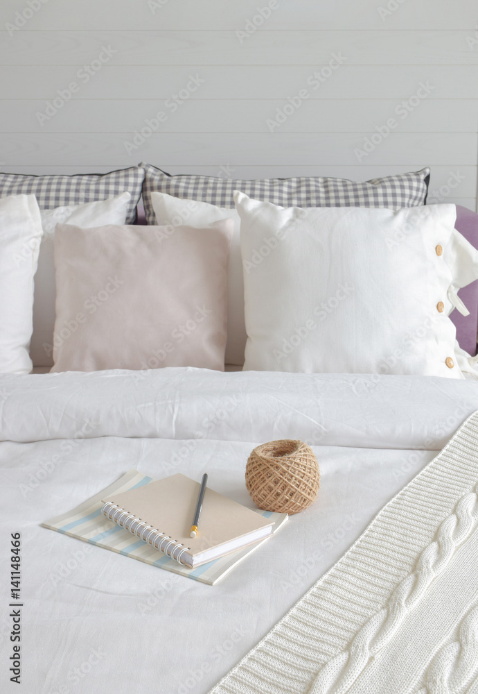 Wall mural Notebook and knitting wool setting on bed in English country style bedding interior