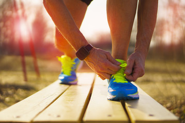 Runner ties his shoes on the bench
