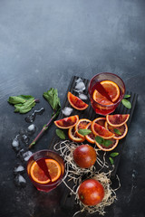 Fresh juice of sicilian blood oranges with mint and ice, high angle view with copy space