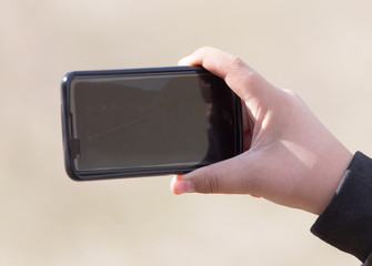 The hand with the phone shoots video
