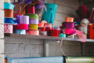 multicolored rolls with ribbons on the shelves