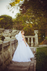Fototapeta premium Beautiful bride walking near old castle before wedding ceremony in church