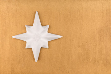 Fototapeta na wymiar White Christmas star on gold background.