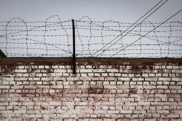 Aged and weatherd brickwall with a barbed wire
