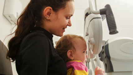 Children ophthalmology - mother and little girl - optometrist Checks Child's Eye