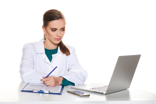 Young Female Student Doctor Sitting With A Laptop On A White Background