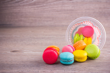 Sweet colorful macaroons on a wood background