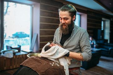 Barber shaves the beard by straight razor