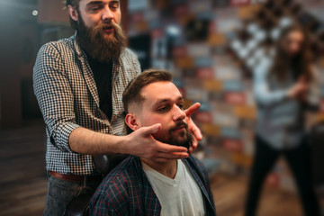 Barber shows his work to the client man