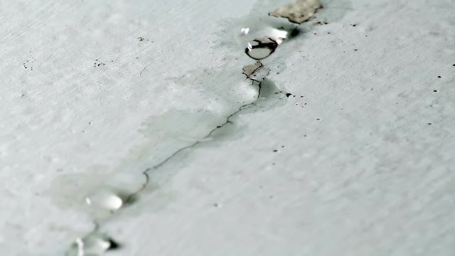 Water drips from ceiling. Faulty water supply in high-rise building. Cracked plaster on the ceiling.