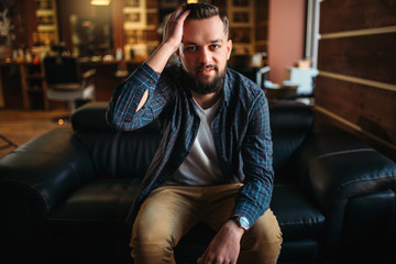 Man waiting on a couch at the hairdressing salon