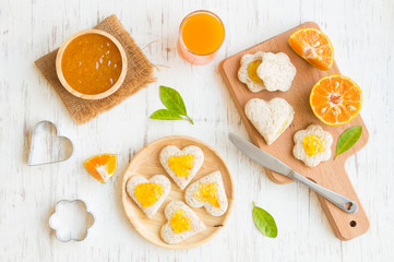 Orange jam with bread set on white rustic wooden table background