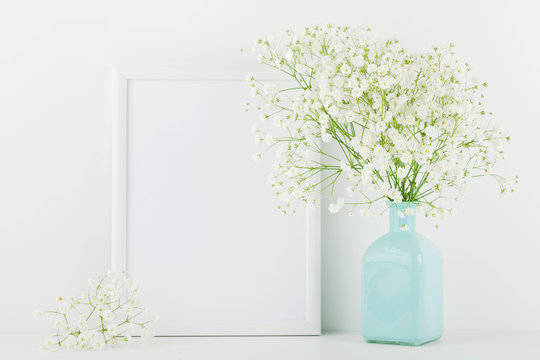 Mockup of picture frame decorated flowers in vase on white background with clean space for text and design your blogging.