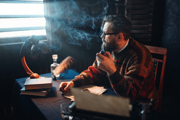 Bearded writer in glasses smoking a pipe
