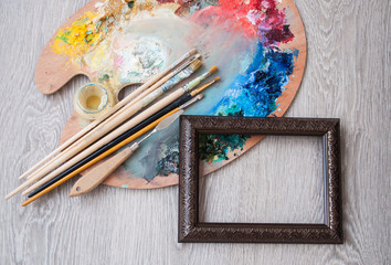 Materials for creativity, palette and brush for painting on a wooden background. The concept of fine art. © ggala