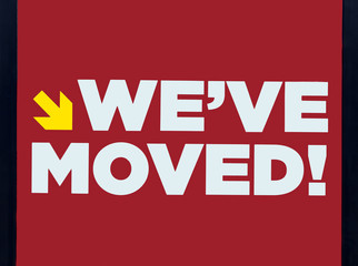 WE'VE MOVED! business sign.