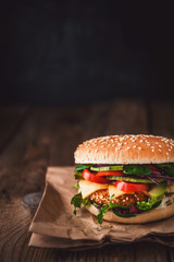 Delicious fresh homemade burger with chicken nuggets and avocado on a wooden table