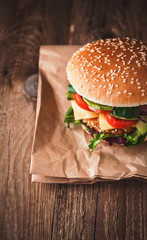 Delicious fresh homemade burger with chicken nuggets and avocado on a wooden table