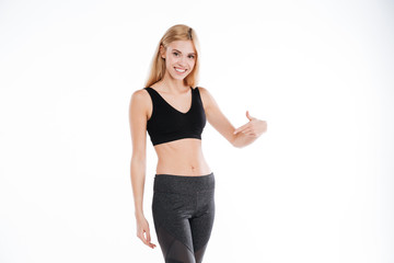 Fototapeta premium Cheerful pretty fitness woman pointing.