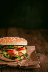 Delicious fresh homemade burger with chicken nuggets and avocado on a wooden table