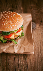 Delicious fresh homemade burger with chicken nuggets and avocado on a wooden table