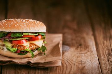 Delicious fresh homemade burger with chicken nuggets and avocado on a wooden table
