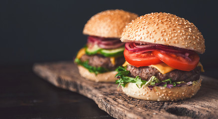 two mouth-watering, delicious homemade burger used to chop beef. on the wooden table.