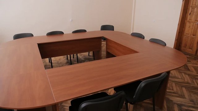 Small conference room with a wooden table, black chairs
