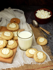 Delicious homemade biscuits. Shortbread with cream cheese cookie and glass of milk on dark background.