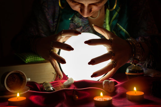 Woman fortune teller looking at crystal ball