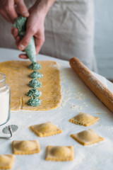 The man is cooking Ravioli with spinach and ricotta cheese