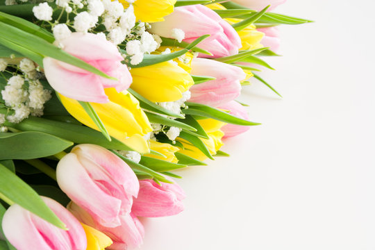 Beautiful bouquet of pink and yellow tulip on white. Close up. Top view.