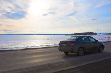 Fototapeta na wymiar car goes on the road lake in winter