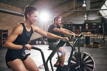 Fototapeta na wymiar Two people having workout on cycling machines