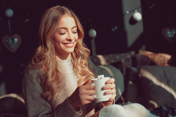 Cheerful woman having hot drink