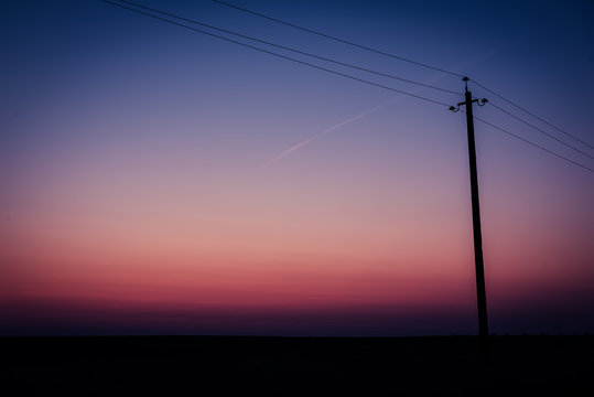 Single electric power pole on at sunrise, natural envirnomental clear energy background
