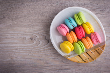 Sweet colorful macaroons on a wood background