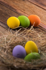 Easter eggs in nest on old wooden background