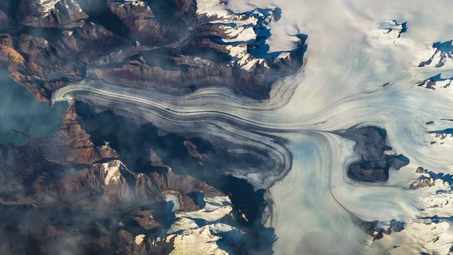 Flying over the earth on the ISS. Flying over the snow-capped mountains, aerial view from space.