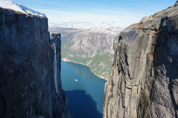 Norwegian fjord between huge mountains in bright day