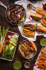Photo sur Plexiglas Grill / Barbecue Grill Food party table concept. Grill Sausage Sandwiches with sweet potatoes fried and  sauce served on rustic table. Top view.