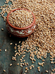 Wheat grains on wooden background. Selective focus.